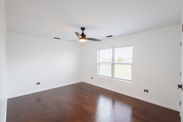 spare room with dark wood-type flooring and ceiling fan