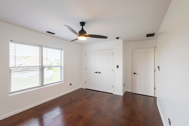 unfurnished bedroom with dark wood-type flooring, ceiling fan, and a closet