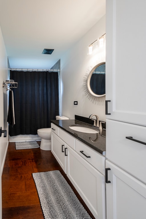 bathroom with vanity, toilet, a shower with shower curtain, and hardwood / wood-style floors