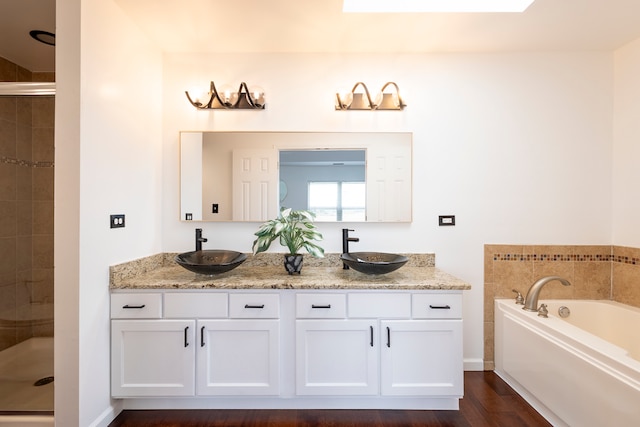 bathroom featuring vanity, hardwood / wood-style flooring, and plus walk in shower