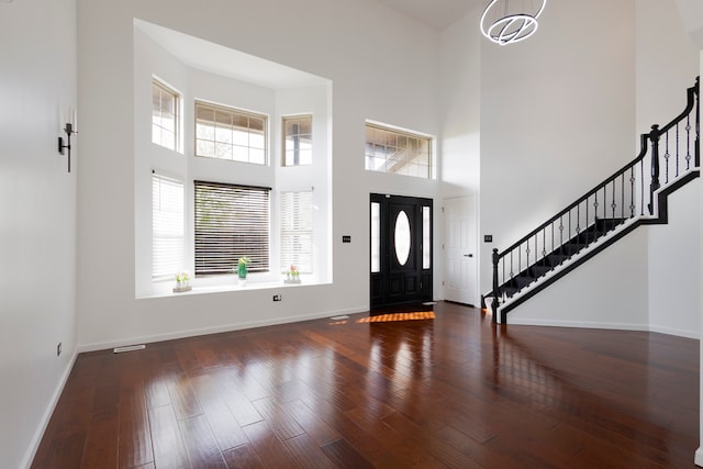 entrance foyer with a high ceiling, plenty of natural light, and dark hardwood / wood-style floors