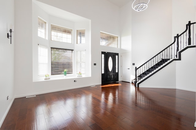 entryway featuring dark wood-type flooring and a high ceiling