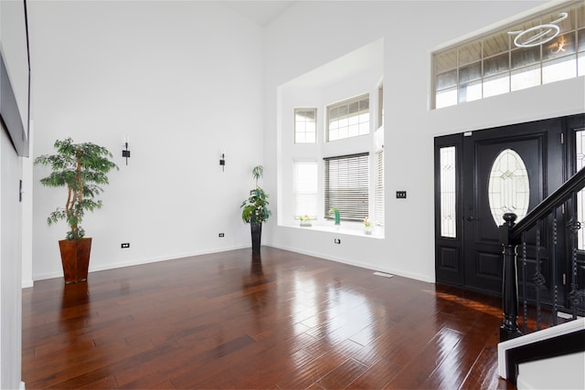 foyer entrance with a high ceiling and dark hardwood / wood-style floors