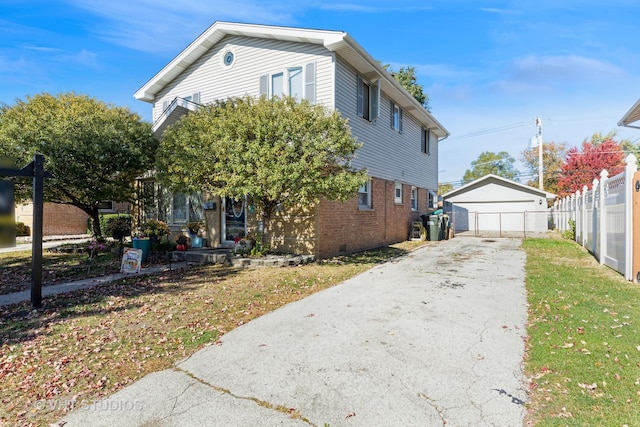 view of front of property with a front yard, a garage, and an outbuilding