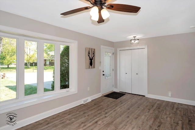 unfurnished bedroom with ceiling fan, dark hardwood / wood-style floors, and multiple windows