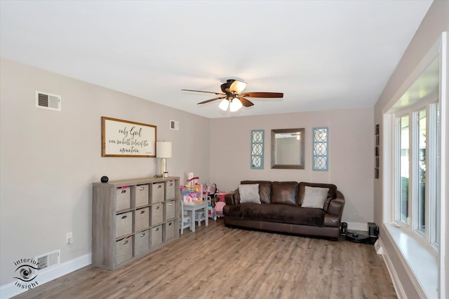 living room featuring ceiling fan and light hardwood / wood-style flooring