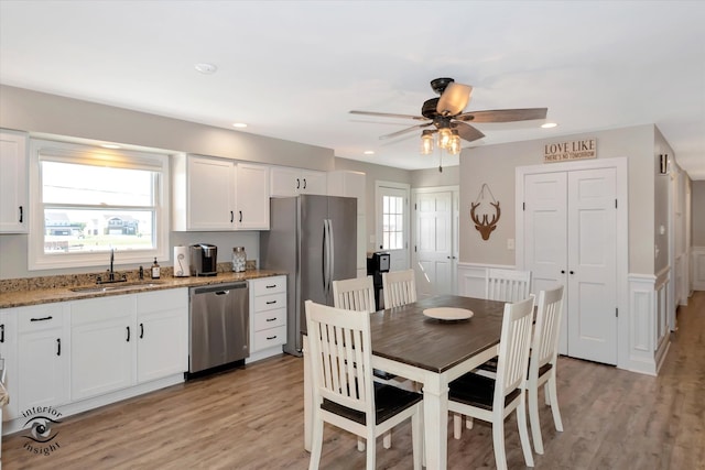 dining space with ceiling fan, sink, and light hardwood / wood-style floors