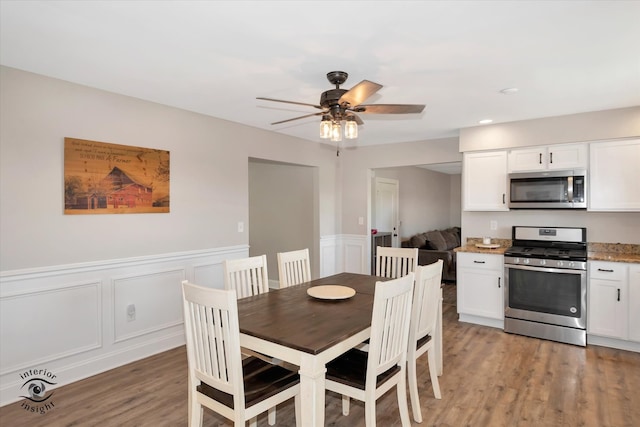 dining area featuring wood-type flooring and ceiling fan