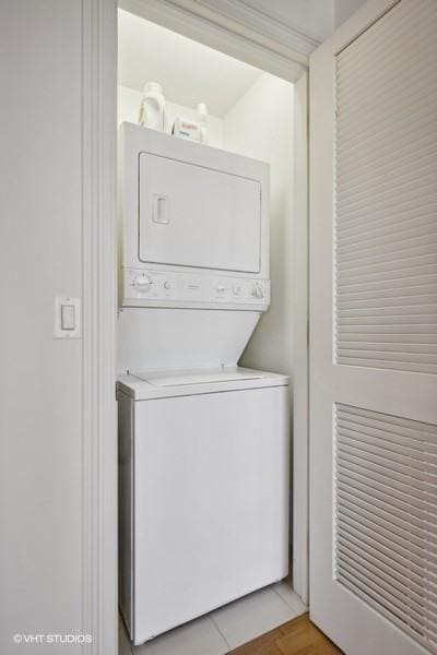 clothes washing area featuring stacked washer and dryer