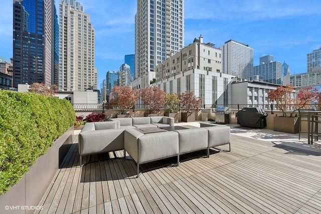 wooden deck with area for grilling and an outdoor hangout area