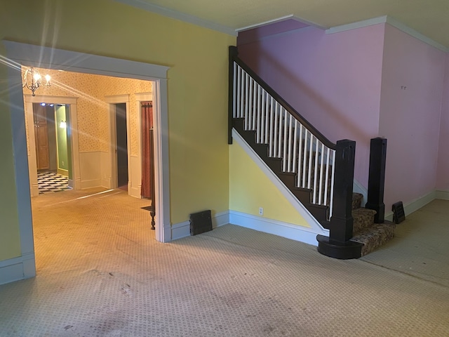 staircase with crown molding, carpet flooring, and an inviting chandelier