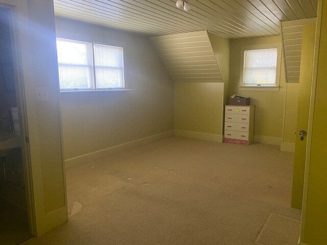 additional living space with vaulted ceiling, wood ceiling, and light colored carpet