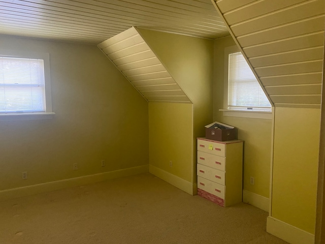 bonus room featuring lofted ceiling, light colored carpet, wooden ceiling, and a wealth of natural light