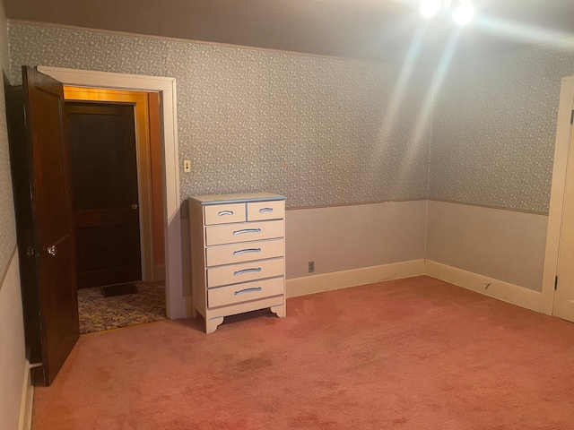 unfurnished bedroom featuring carpet and lofted ceiling