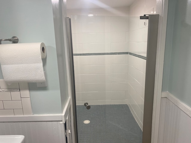 bathroom with a tile shower and toilet