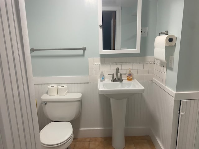 bathroom featuring toilet, sink, and tile patterned flooring