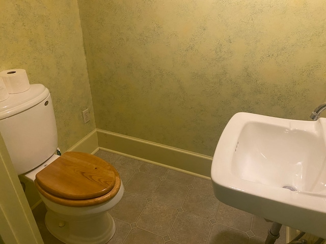 bathroom with sink, toilet, and tile patterned flooring