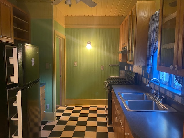 kitchen featuring ceiling fan, sink, stove, and black refrigerator