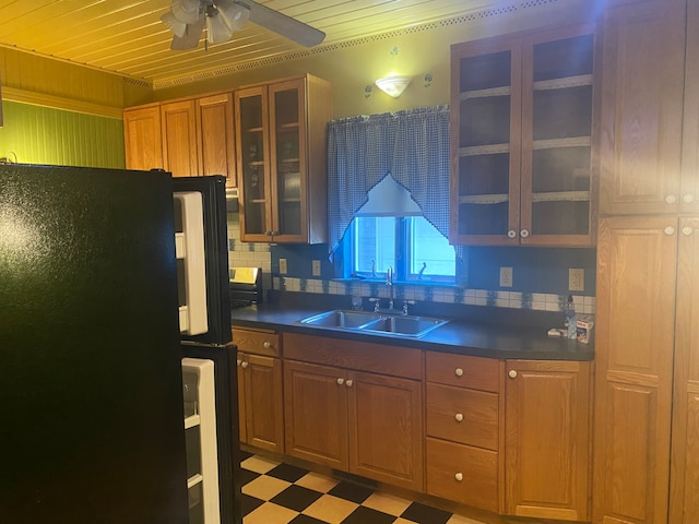 kitchen with wood ceiling, tasteful backsplash, sink, and black refrigerator