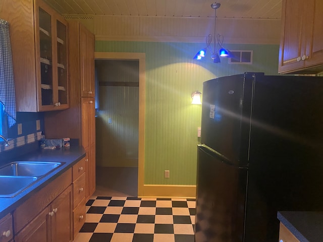 kitchen with sink, wood ceiling, hanging light fixtures, a chandelier, and black refrigerator