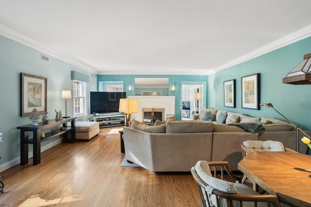 27 Hickory Ln, White Heath, IL 61884 - living room featuring ornamental molding, light wood-type flooring, and a glass covered fireplace