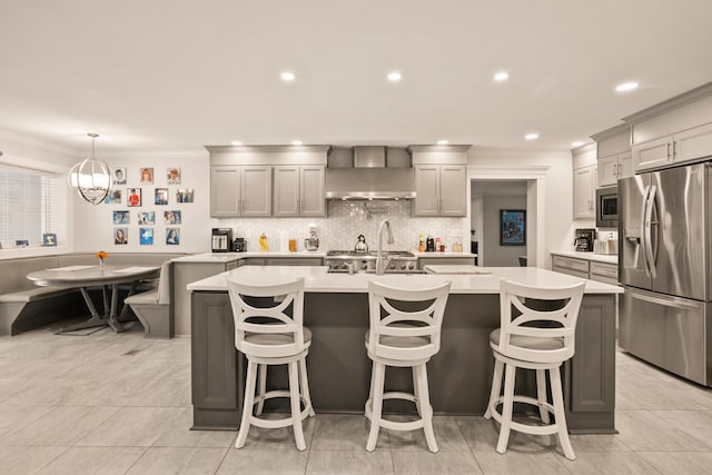 27 Hickory Ln, White Heath, IL 61884 - kitchen featuring stainless steel appliances, ornamental molding, light countertops, backsplash, and an island with sink