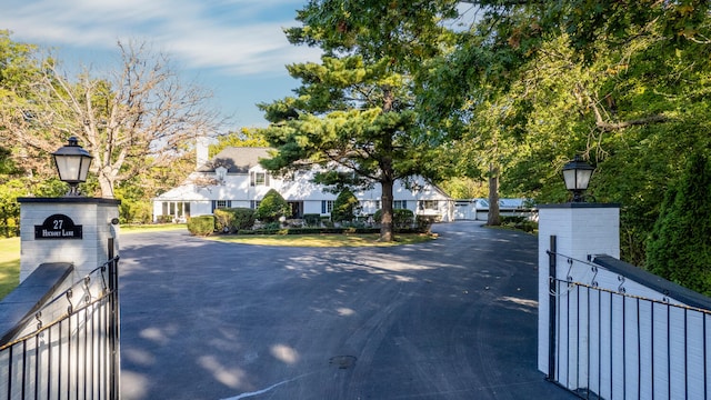 27 Hickory Ln, White Heath, IL 61884 - view of asphalt driveway featuring street lighting, a residential view, and a gated entry