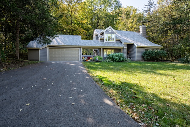 cape cod-style house featuring a garage and a front lawn