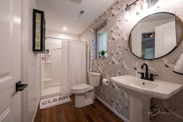 bathroom with hardwood / wood-style floors, a shower with shower curtain, and toilet