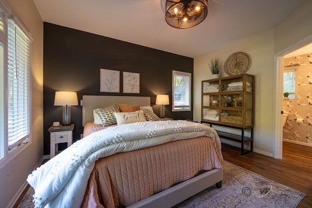 bedroom featuring dark hardwood / wood-style flooring and ensuite bath