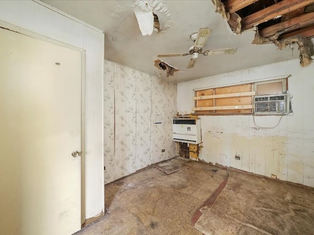 interior space with ceiling fan, a wall mounted AC, and heating unit