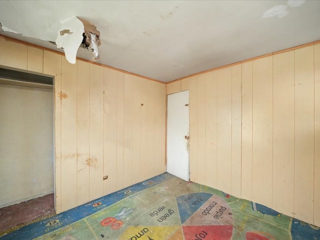 unfurnished bedroom with wooden walls and a closet