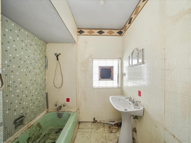 bathroom featuring washtub / shower combination, tile patterned floors, and tile walls