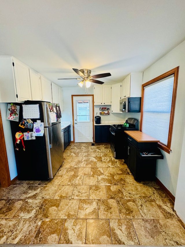 kitchen featuring stainless steel appliances, white cabinets, and ceiling fan