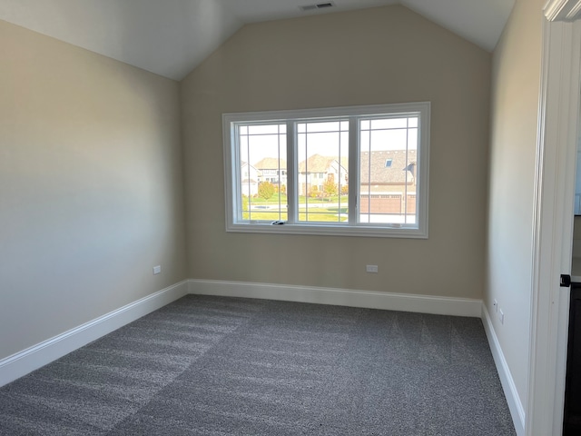 carpeted empty room with vaulted ceiling