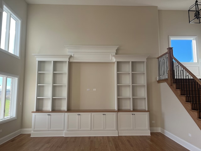 unfurnished living room with a chandelier and dark hardwood / wood-style flooring