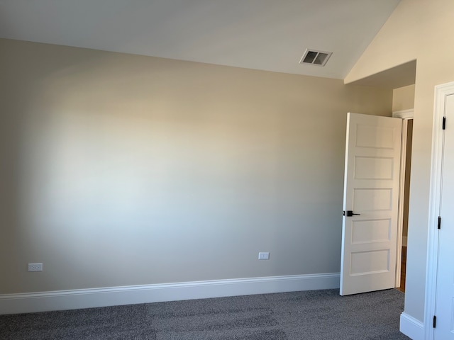 carpeted spare room featuring vaulted ceiling