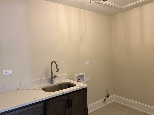 washroom featuring hookup for a washing machine, cabinets, sink, and light hardwood / wood-style flooring