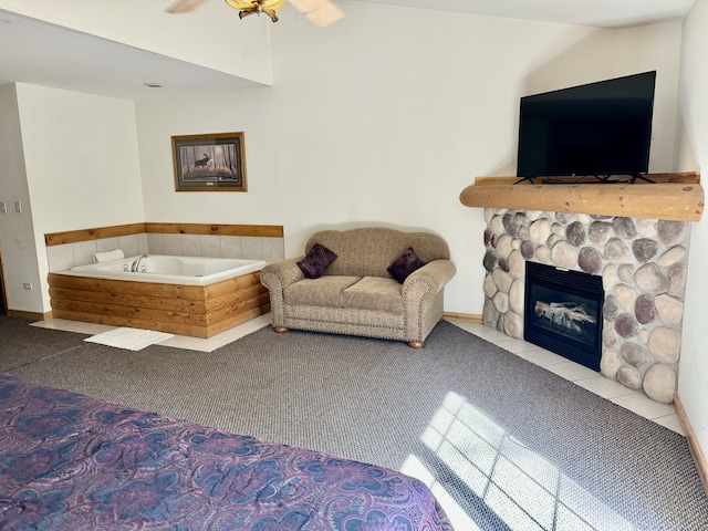 living room featuring ceiling fan, a stone fireplace, and carpet