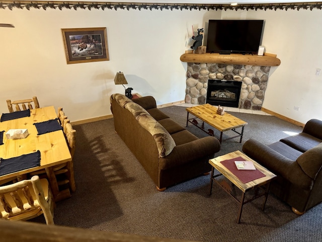 carpeted living room with a stone fireplace