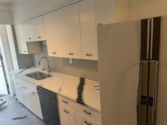 kitchen with tasteful backsplash, sink, dishwasher, light stone countertops, and white cabinetry