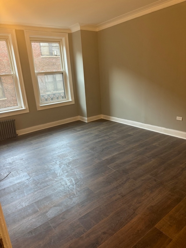 unfurnished room with dark hardwood / wood-style floors, crown molding, and radiator