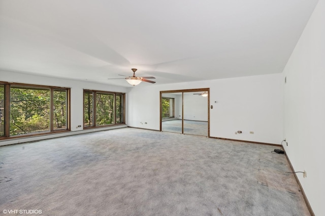 empty room featuring light carpet, a baseboard radiator, and ceiling fan