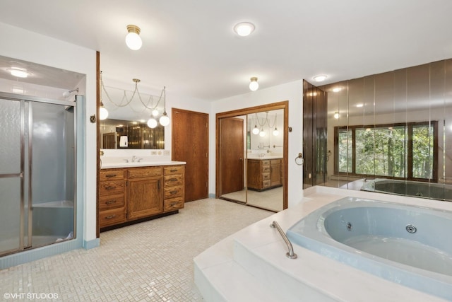 bathroom featuring tile patterned flooring, vanity, separate shower and tub, and a notable chandelier