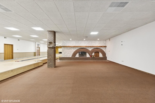 basement with a paneled ceiling, a fireplace, and carpet