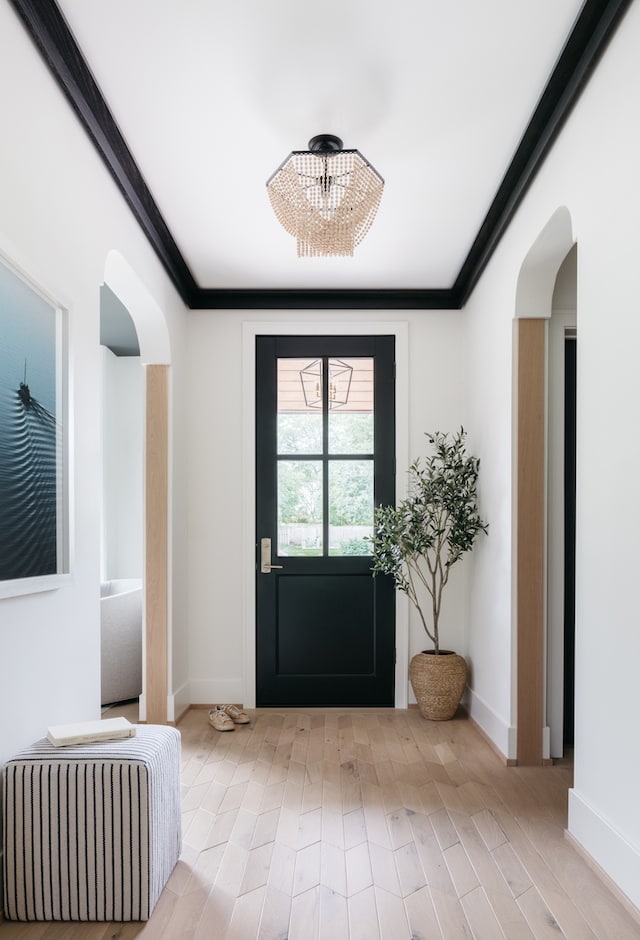 doorway to outside featuring light hardwood / wood-style floors, a chandelier, and ornamental molding