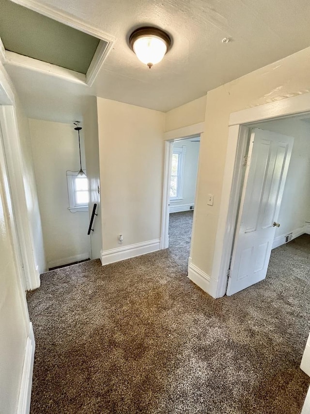 carpeted empty room with a textured ceiling