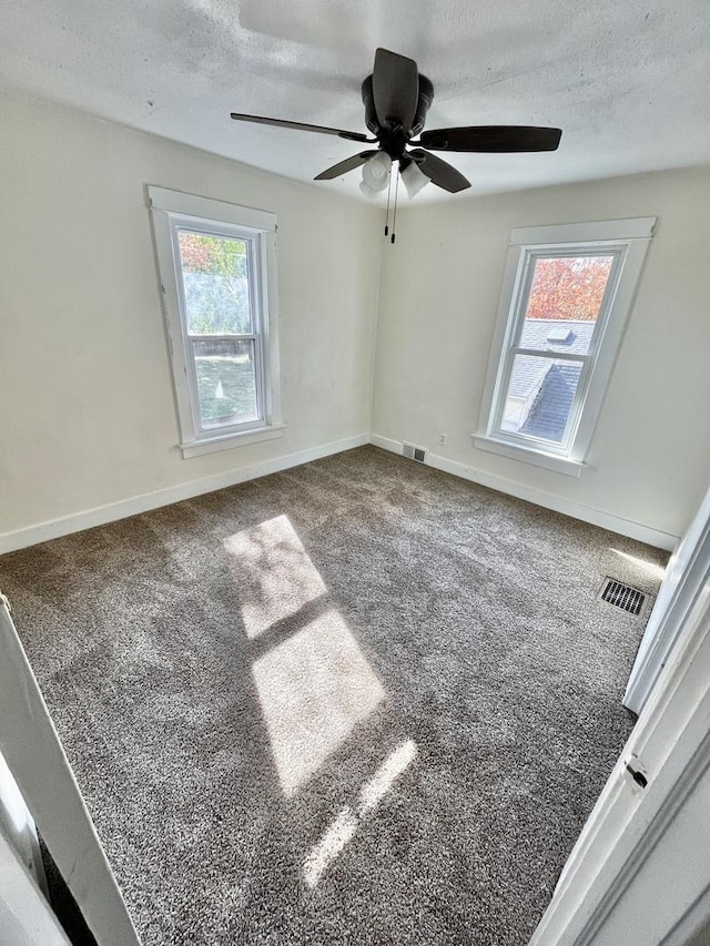 unfurnished room with carpet flooring, ceiling fan, and a textured ceiling