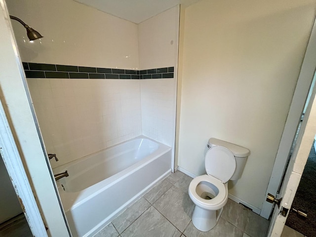 bathroom with tile patterned flooring, tiled shower / bath combo, and toilet