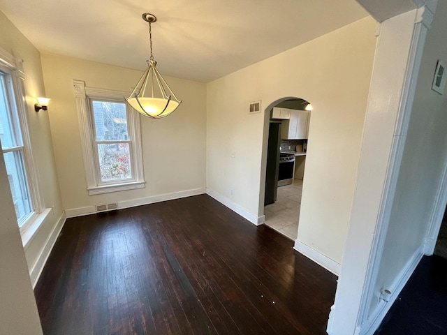 unfurnished dining area featuring dark hardwood / wood-style flooring